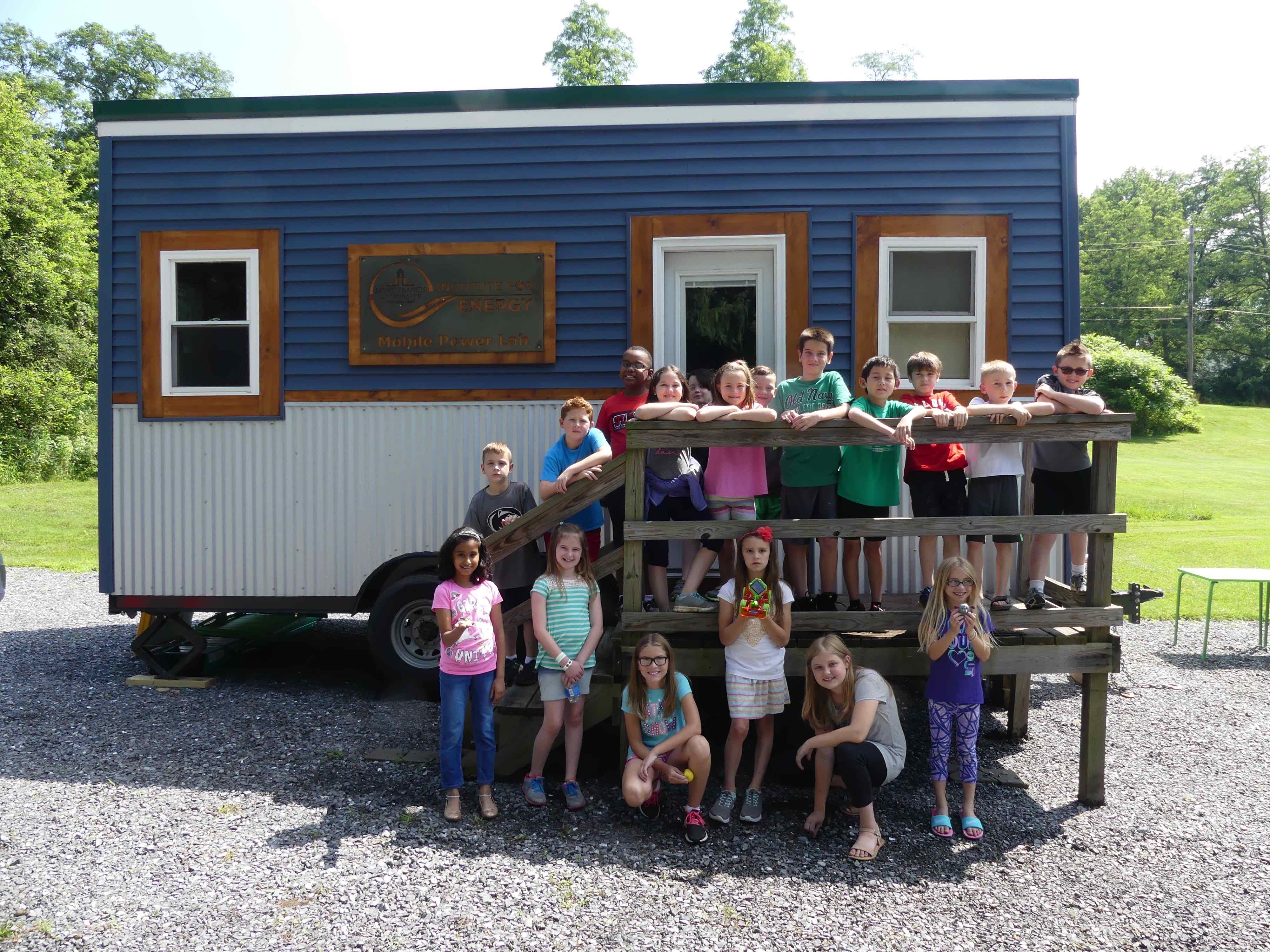 summer camp students posing in front of Tiny House classroom at SFU