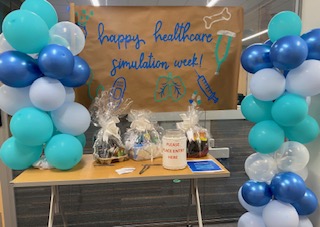 Image of Healthcare Simulation Week celebratory banner and prize display area located in the ELC.