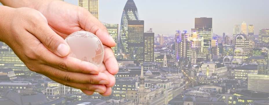 Glass globe in hands over a cityscape