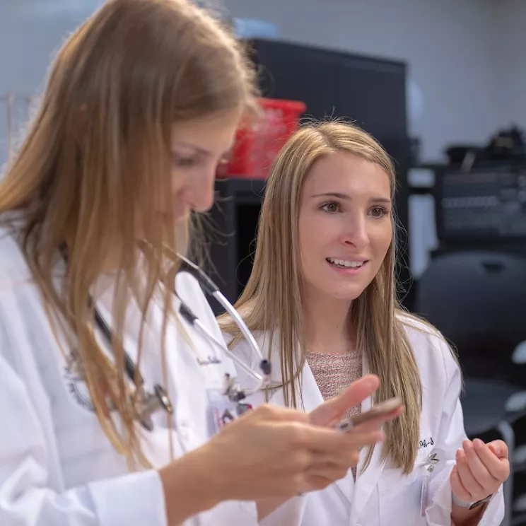 Students in white lab coats enjoying learning