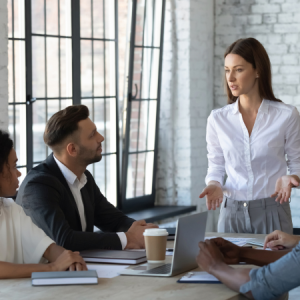 Young business leader speaks with their team during a meeting