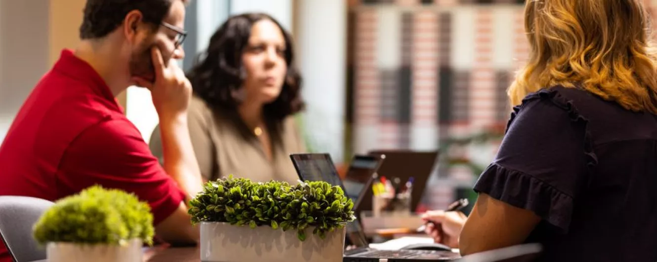 three professionals at a desk working