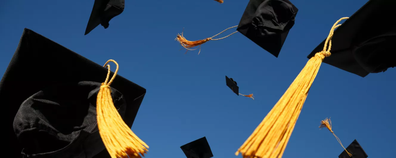 graduation caps in the air