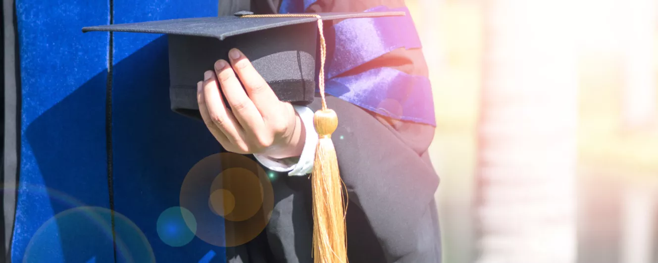 photo of doctoral degree graduate holding cap