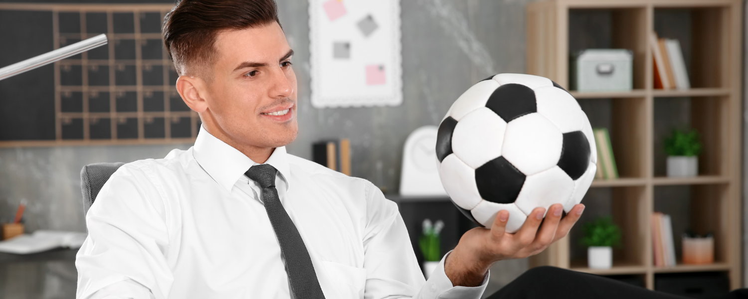 Sports Administration web banner, man in suit holding a soccer ball