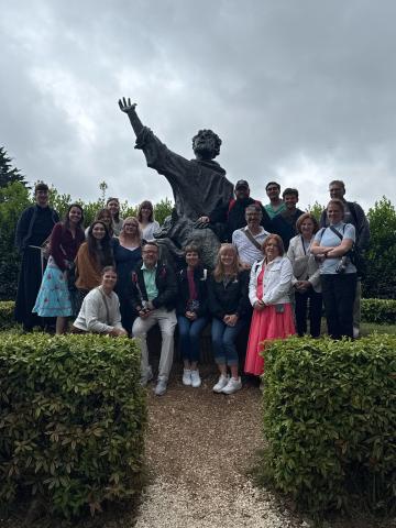 Pilgrimage group with st francis and wolf statue