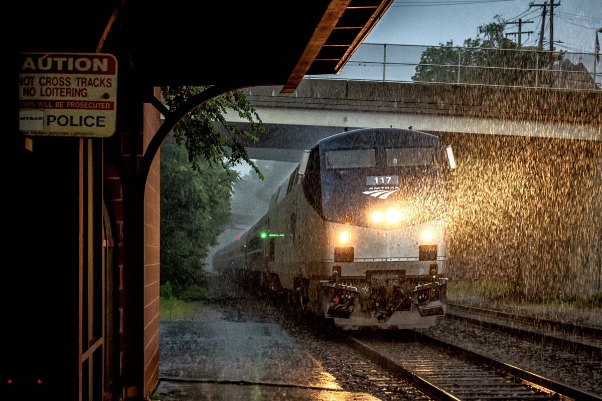 Train passing station in the rain